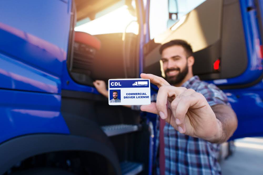 Benefits of CDL license - a truck driver holding his license.